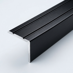 Black brushed aluminum stair nosing profile with anti-slip grooves, shown in close-up on a white background.