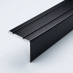 Black brushed aluminum stair nosing profile with anti-slip grooves, shown in close-up on a white background.