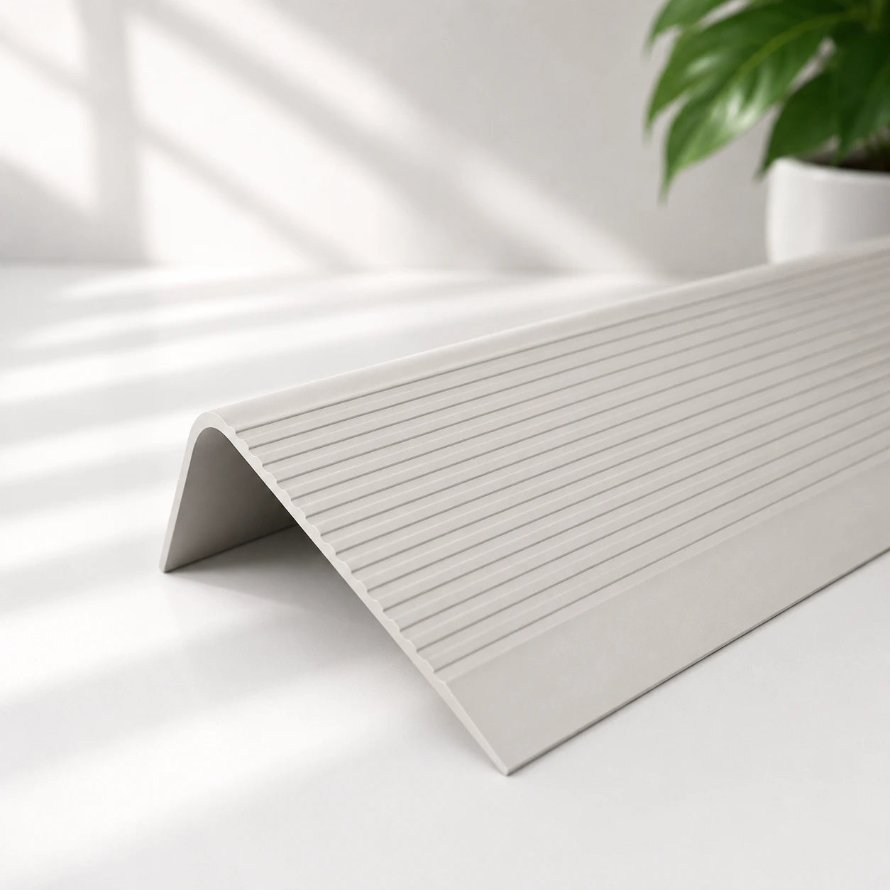 Flexible PVC anti-slip stair nosing profile in grey colour with textured grooved surface for enhanced stair edge safety and protection