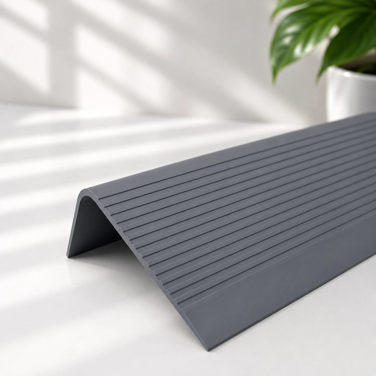 Flexible PVC anti-slip stair nosing profile in dark grey colour with textured grooved surface for enhanced stair edge safety and protection