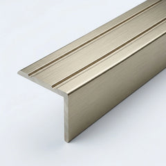 Inox brushed aluminum stair nosing profile with anti-slip grooves, shown in close-up on a white background.